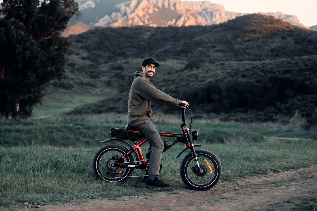 a man sitting on top of a bike on a dirt road